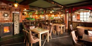 a restaurant with tables and chairs and a fireplace at Hotel Heimathafen in Lörrach