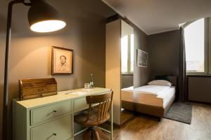 a bedroom with a desk and a bed in a room at Hotel Heimathafen in Lörrach