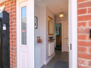 a door leading into a hallway with a brick wall at Pinecote Cottage in Nottingham +21 photos