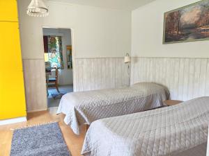 a room with two beds and a table with a chair at Guesthouse Veteli in Veteli