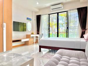 a bedroom with a bed and a tv and a couch at Супер апартаменты Найтон Naithon in Nai Thon Beach