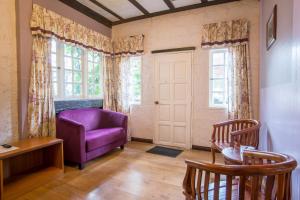 a living room with a purple chair and a window at The Bala's Holiday Chalet in Cameron Highlands