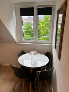 a white table and chairs in a room with two windows at Appartement-Koblenz in Koblenz