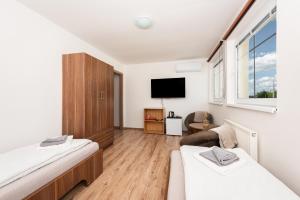 a small room with two beds and a tv at Penzion Maja in Martin