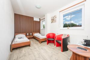 a room with two beds and a desk and chairs at Penzion Maja in Martin