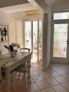 a kitchen with a table and chairs and a sliding glass door at 2Steps Capri - central holiday house in Capri