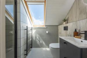 a bathroom with a toilet and a sink and a window at The Haybarn - Hot Tub - Free WiFi & Parking - Pets Welcome in Mousehole +26 photos