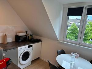 a kitchen with a washing machine and a table at Appartement-Koblenz in Koblenz +10 photos