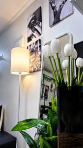 a room with a mirror and a lamp and a vase with flowers at La Petite Maison d'Hôtes in Seoul