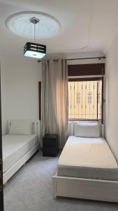 a bedroom with two beds and a window at Firras Mdiq in M'diq