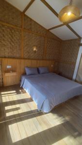 a bedroom with a large bed in a room at Morgans Bungalows in Maluk