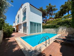 a swimming pool in front of a house at Ada Villas in Kuşadası