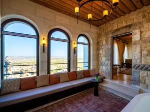 a living room with a couch in a room with windows at Cybele in Cappadocia in Uçhisar