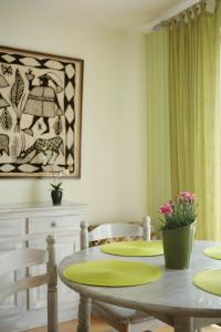 a dining room with a table and chairs and a painting at Au coeur du golfe in Sarzeau