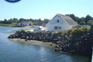 a house on the shore of a body of water at Au coeur du golfe in Sarzeau