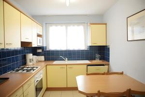a kitchen with yellow cabinets and a table and a window at Au coeur du golfe in Sarzeau