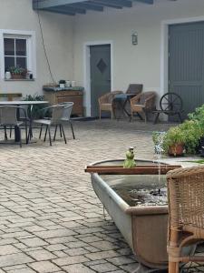 a courtyard with a fountain with chairs and tables at Little-Lama-Lodge in Naila
