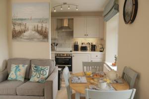 a kitchen and dining room with a table and a couch at 10 The Downs, Thurlestone overlooking Burgh Island in Kingsbridge