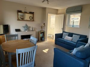a living room with a blue couch and a table at 10 The Downs, Thurlestone overlooking Burgh Island in Kingsbridge