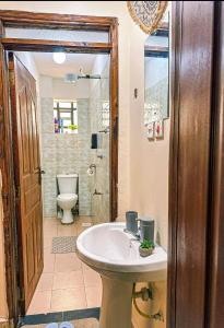 a bathroom with a sink and a toilet at Stylish Ngong Retreat with Balcony & Rooftop Lounge The Moon Stays in Ngong +6 photos