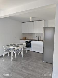 a kitchen with a table and chairs and a refrigerator at Ola's House in Bradu