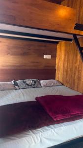 a bed in a room with a wooden wall at Apm resort kodai in Kodaikānāl