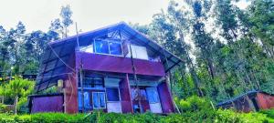 a house that is sitting in the forest at Apm resort kodai in Kodaikānāl