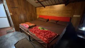 a bedroom with a bed with a red headboard at Apm resort kodai in Kodaikānāl
