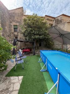 a swimming pool with chairs and an umbrella at Cal Rabell in Bellmunt