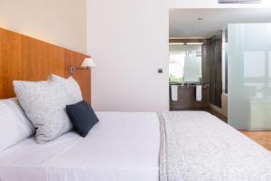 a bedroom with a white bed with two pillows at RVHotels Nautic Park in Platja d'Aro