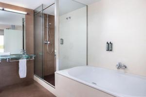 a bathroom with a tub and a glass shower at RVHotels Nautic Park in Platja d'Aro +33 photos