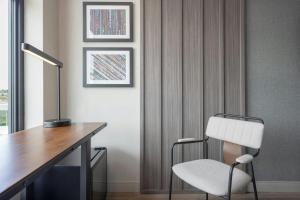 a room with a desk and a white chair at Moxy Portland Thompson's Point in Portland