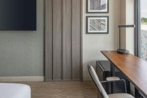 a hotel room with a desk and a table and chairs at Moxy Portland Thompson's Point in Portland