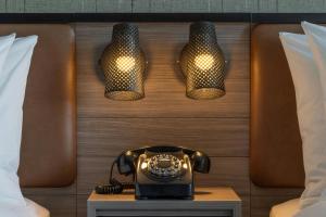 a hotel room with a phone and three lights at Moxy Portland Thompson's Point in Portland