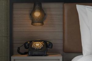 a telephone on a table next to a bed at Moxy Portland Thompson's Point in Portland +1 photo