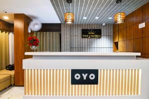 a reception desk in a hotel with a sign on it at Hotel O The Crown in Kolkata +21 photos