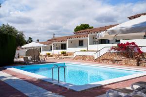a swimming pool with a villa in the background at Mas Boronat Resort in Salomó