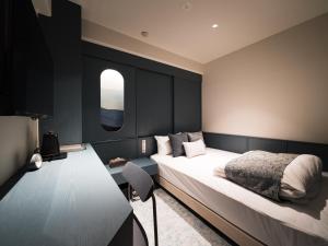 a bedroom with a large bed and a window at R Hotel Nagoya Station in Nagoya