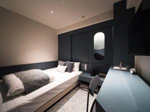 a bedroom with a bed and a desk and a mirror at R Hotel Nagoya Station in Nagoya +5 photos