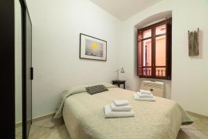 a bedroom with a bed with towels on it at Sardinian Gallery Corso in Bosa