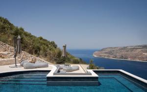 a swimming pool with a view of the water at The One Limeni in Limeni