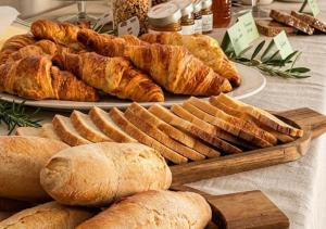 a table topped with plates of bread and pastries at Amandelia in Fardella