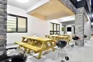 a group of wooden tables in a room with windows at Samcheok blossom pension in Samcheok