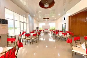 a banquet hall with tables and chairs and red bows at Pilot Hotel in Amandiego