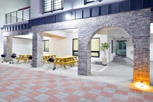 a room with two tables and a brick archway at Samcheok blossom pension in Samcheok +1 photo