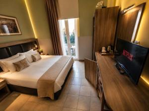 a hotel room with a bed and a television in it at Diethnes Hotel in Athens