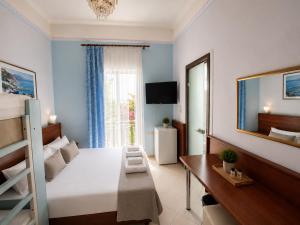a bedroom with a bed and a desk and a window at Diethnes Hotel in Athens