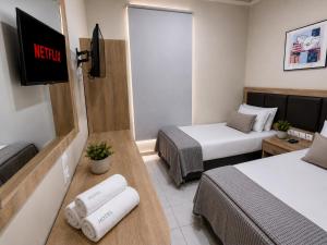 a small room with two beds and a tv at Diethnes Hotel in Athens +63 photos