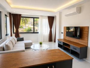 a living room with a couch and a tv at Bodrum Blue Bay Hotel & Restaurant in Bodrum City