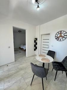 a living room with a table and two chairs at Casa Racolța Central Garden in Câmpia Turzii